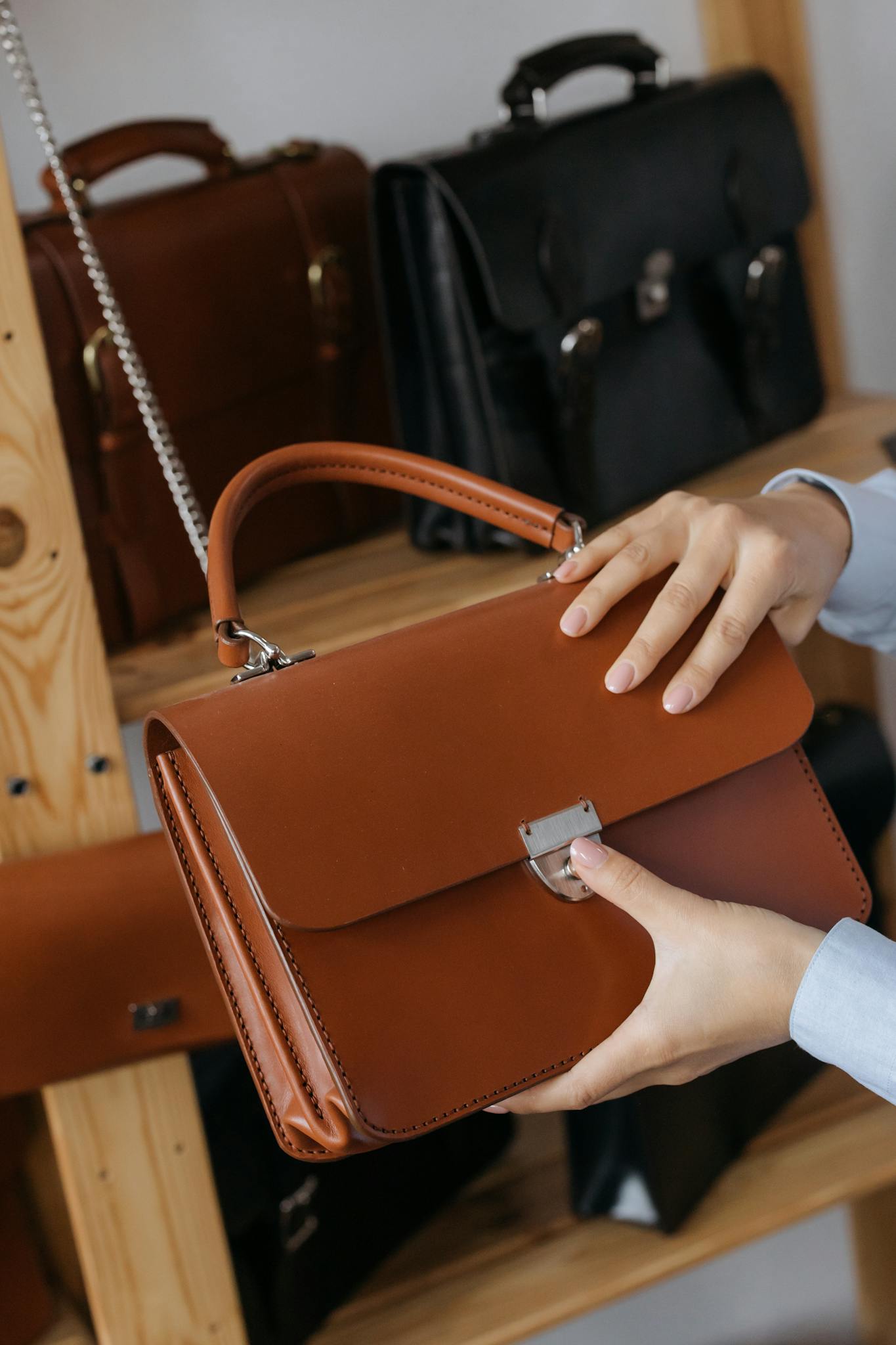 A stylish leather handbag being presented in a sleek, modern showroom setting.